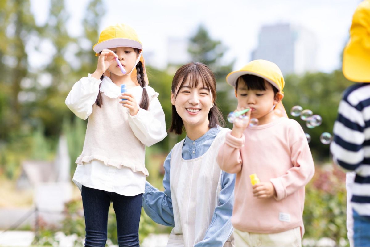 cô giáo và trẻ vui đùa ngoài trời